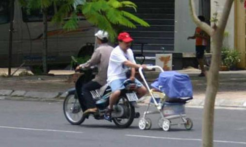 Pas facile de faire de la mob avec un bébé... Sauf quand on est astucieux ! hop, un qui se retourne et on tire la poussette ! Et tant pis pour les gaz d'échappements height=